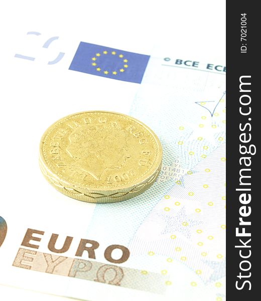 Close-up of a pound coin on twenty euro banknote. Close-up of a pound coin on twenty euro banknote.