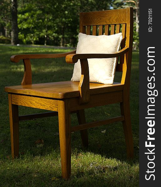 Old wood chair on the grass with pillow. Old wood chair on the grass with pillow