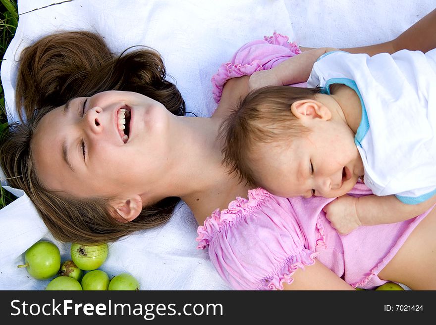 Little girl and her baby brother lying among apples. Little girl and her baby brother lying among apples