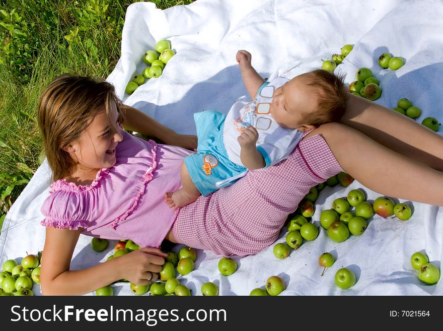 Little girl and her baby brother lying among apples. Little girl and her baby brother lying among apples