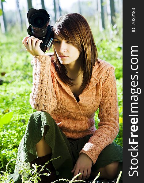 Young pretty female photographer in a forest.