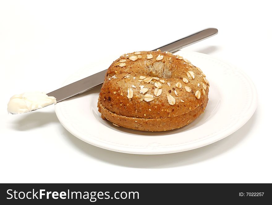 Freshly baked bagel with butter on a white background. Freshly baked bagel with butter on a white background