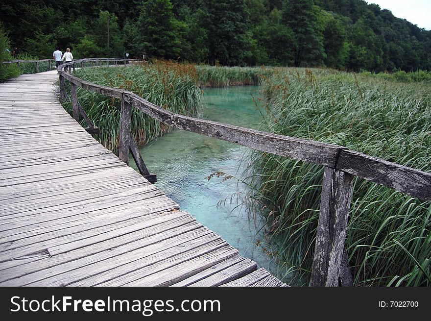 A couple waking on a wooden bridge