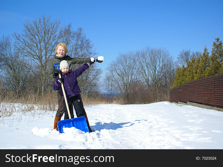 Mother and her daughter throw up snow on a winter background. Mother and her daughter throw up snow on a winter background