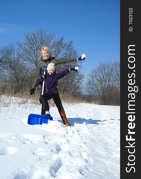 Mother and her daughter throw up snow on a winter background. Mother and her daughter throw up snow on a winter background