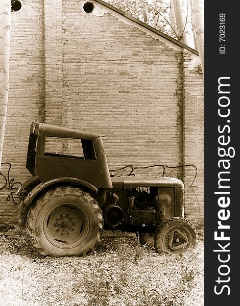 Abandoned tractor close to an old building. Abandoned tractor close to an old building.