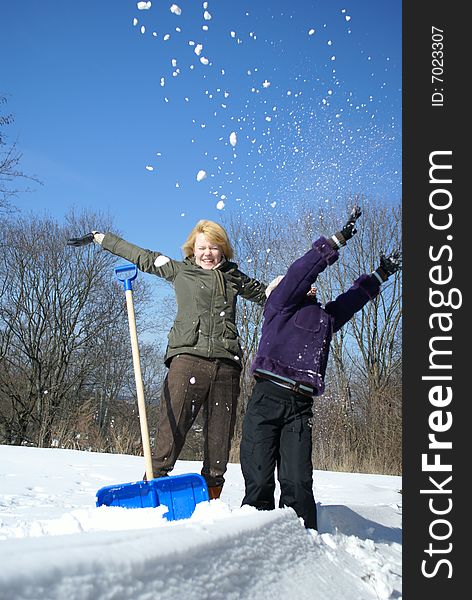 Mother and her daughter throw up snow on a winter background. Mother and her daughter throw up snow on a winter background