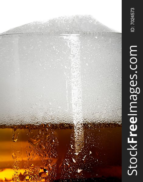 Fresh amber beer with froth in a glass, background