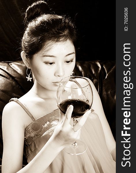 Asian female holding goblet with red wine. Asian female holding goblet with red wine