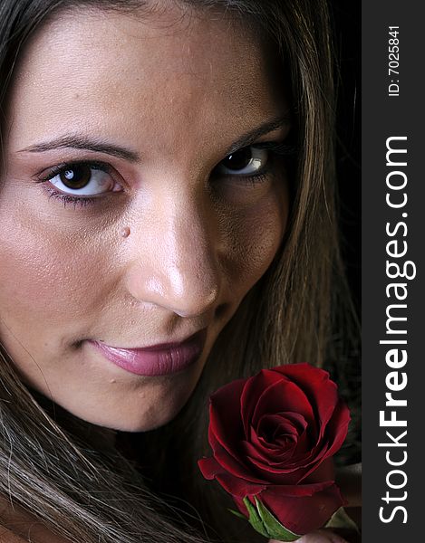 Beautiful young brunette woman holding a red rose for valentines. Beautiful young brunette woman holding a red rose for valentines