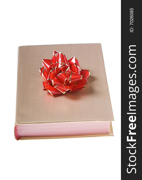 Book wrapped golden paper with red and yellow bow on top. Book wrapped golden paper with red and yellow bow on top