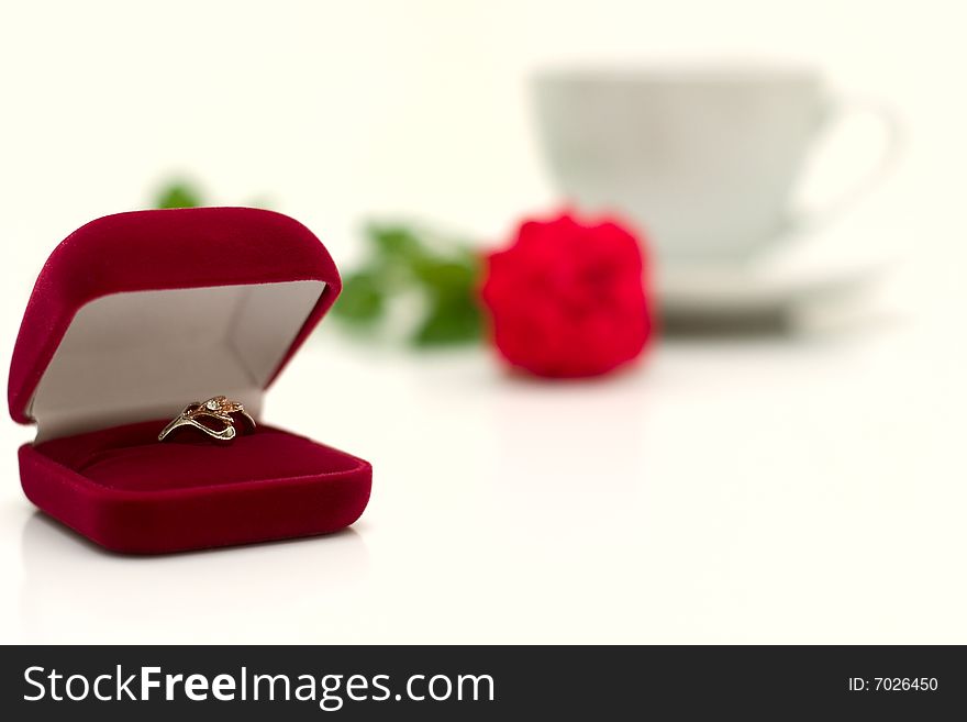 Box with a ring against a cup and a rose. The exciting moment of a life.