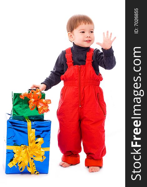 Cute two year old boy with a lot of presents waiving his hand