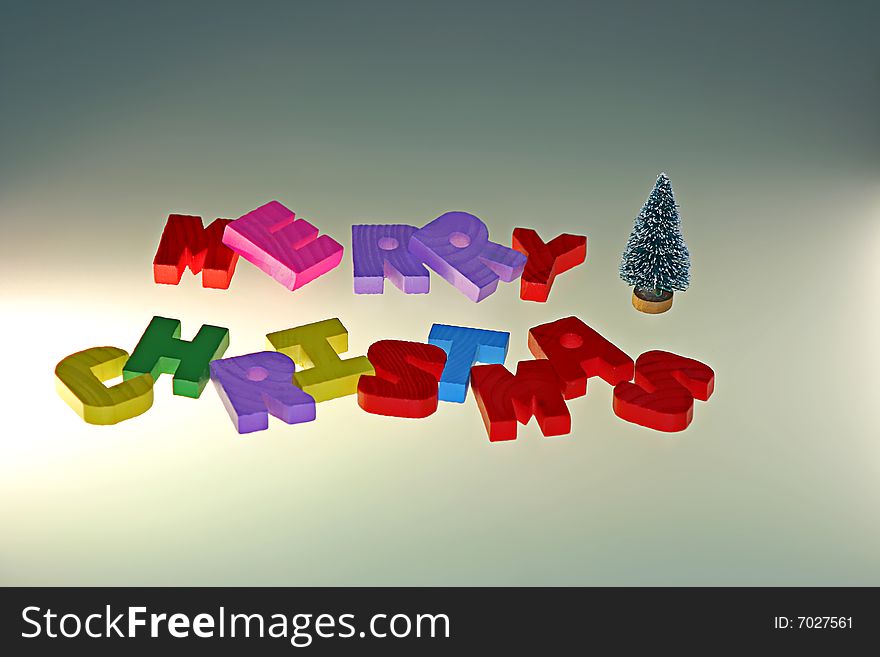 Merry Christmas wood letters and small christmas tree with warm light