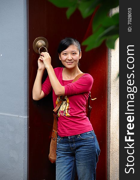 A woman with red door background. A woman with red door background