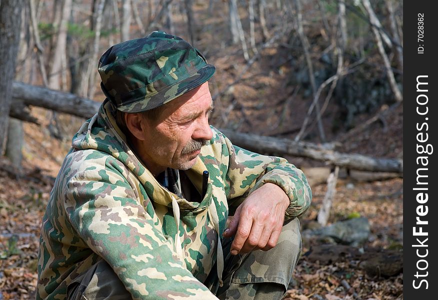 A man in camouflage suit is in forest. Autumn, sunny day. A man in camouflage suit is in forest. Autumn, sunny day.