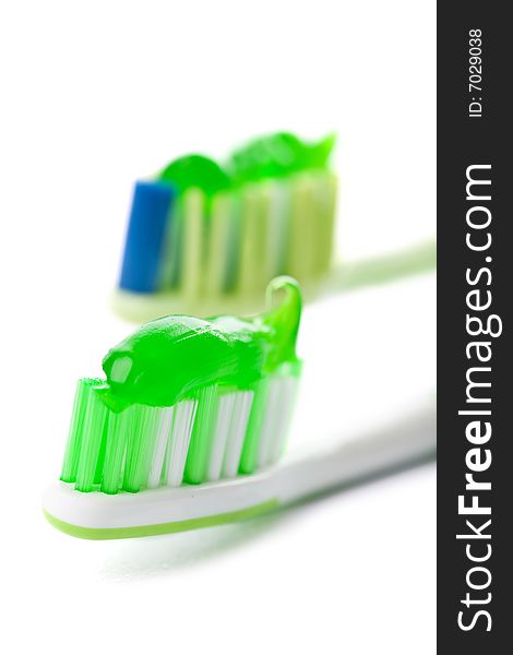 Two Toothbrushes With Green Toothpaste Isolated