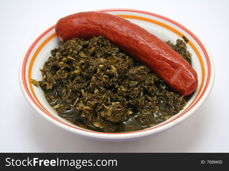 A meal of fresh green cabbage with sausages