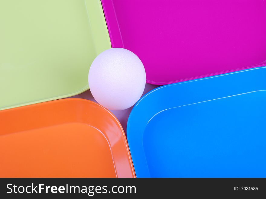 White egg among colorful plates. White egg among colorful plates