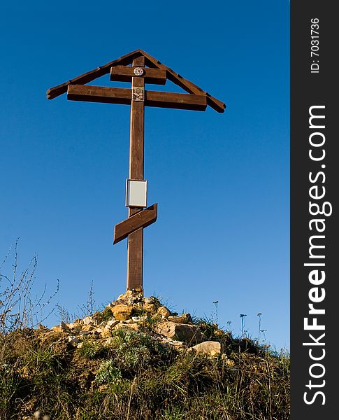 Cross on the hill behind blue sky