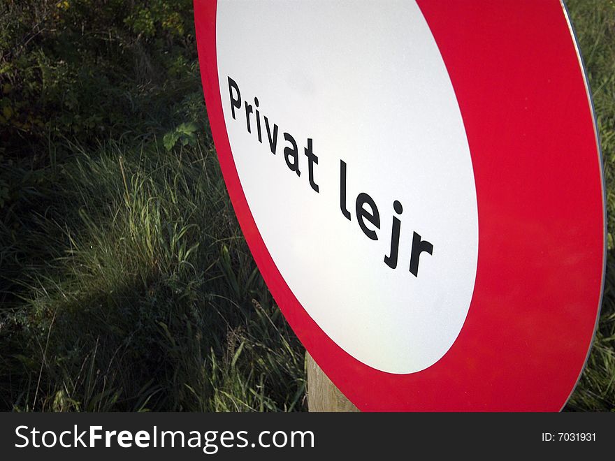 Private camp sign in red and white and in Danish language on private property. Private camp sign in red and white and in Danish language on private property