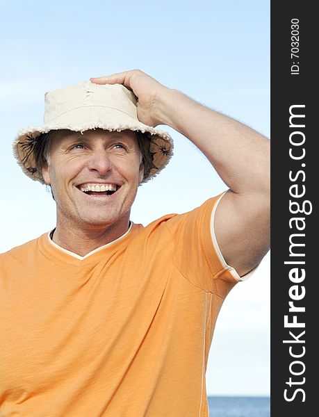 A happy handsome man in his forties laughs as he enjoys himself on the beach. A happy handsome man in his forties laughs as he enjoys himself on the beach