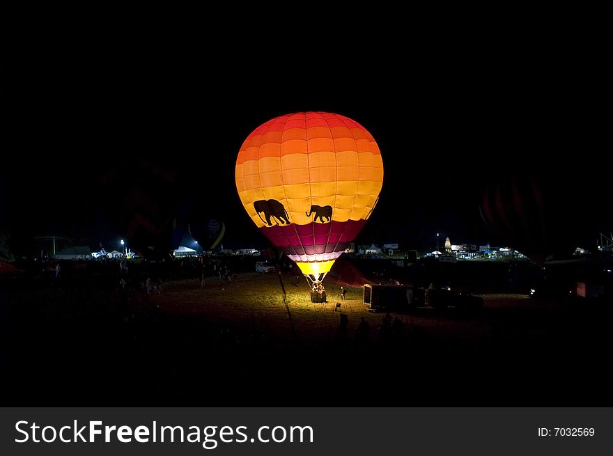 A hot air balloon glowing at night.
