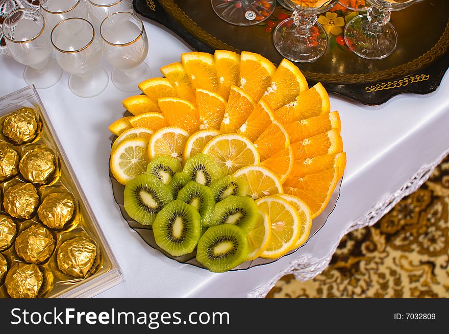 Fruit oranges, lemons, kiwi and chocolate on a dining table. Fruit oranges, lemons, kiwi and chocolate on a dining table.