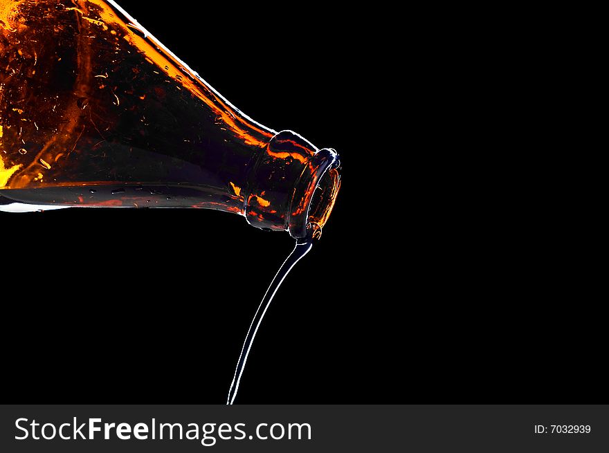 Close-up water flowing from bottle isolated on black