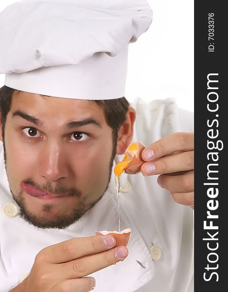 Young funny chef cracking an egg