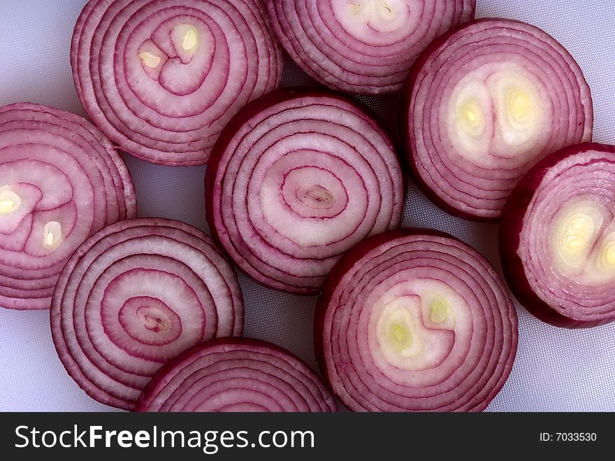 Onion rings sliced and laid out on a chopping board