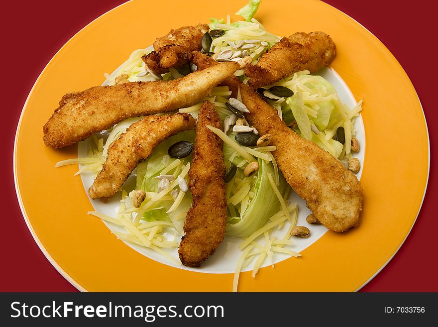 Salad with turkey stripes, on plate for a meal dressed