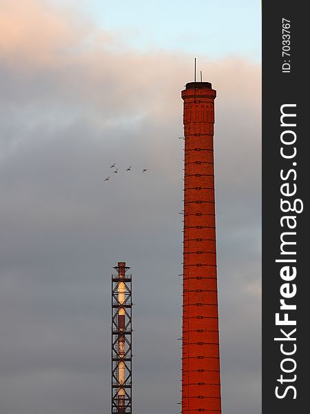 Two industrial stacks. The crowd of birds flying by. Two industrial stacks. The crowd of birds flying by.