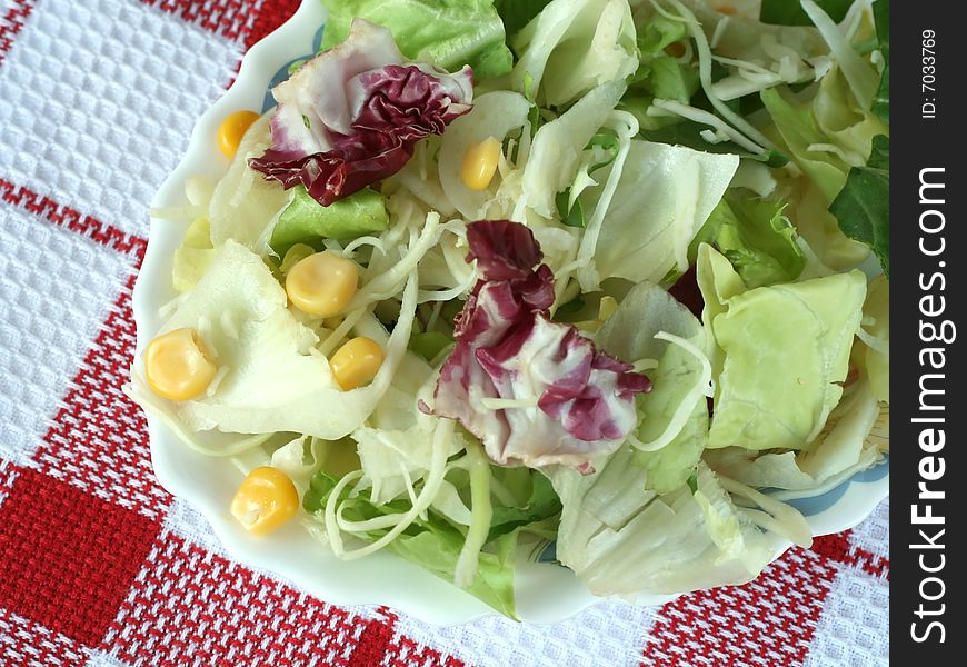 Green Salad With Corn In A Plate On Checked Tabl