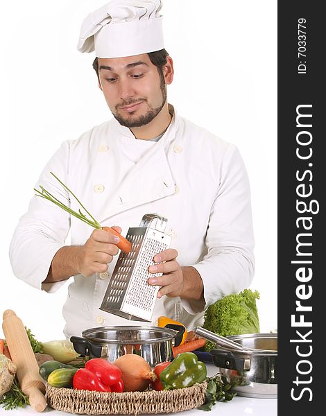 Young chef preparing lunch and cutting carrot with stainless grater