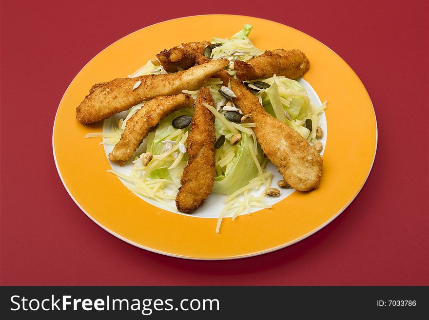 Salad with turkey stripes, on plate for a meal dressed