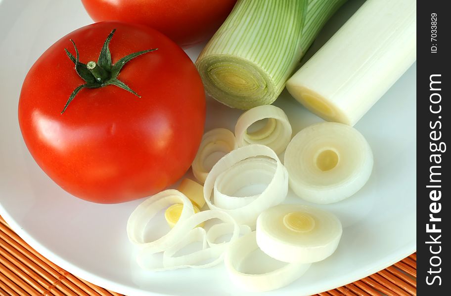 Tomato and leek on a plate closeup