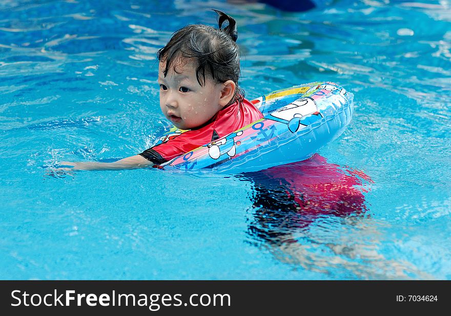 Beautiful little girl swimming in the swimming pool. Beautiful little girl swimming in the swimming pool