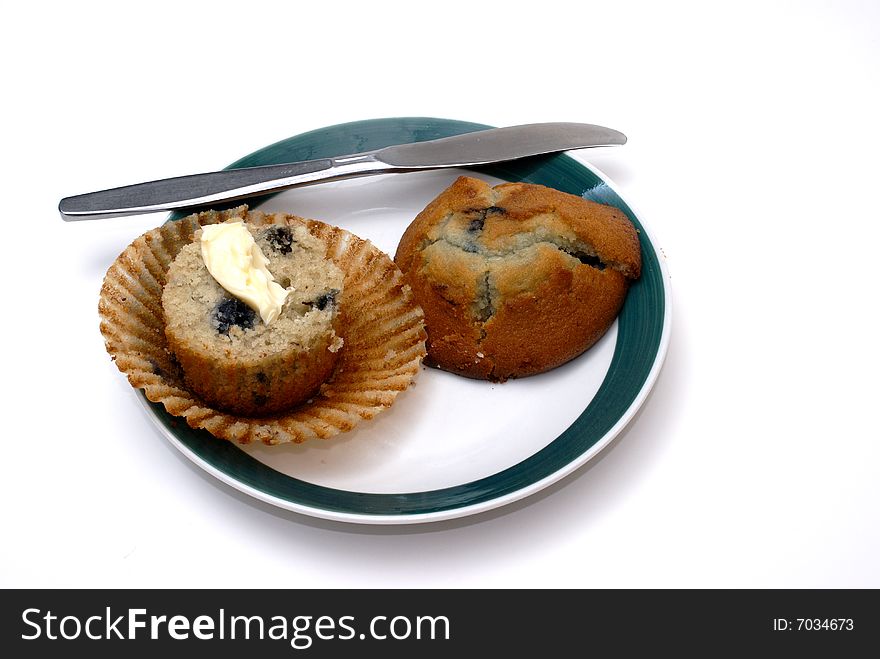 A freshly baked blueberry muffin with butter.
