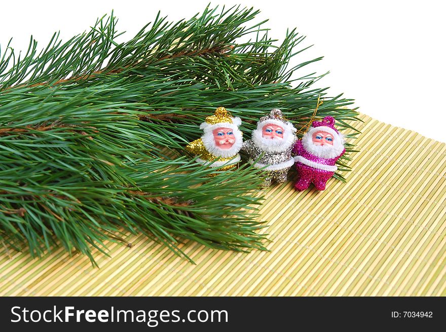 Three Santas sitting on  bamboo mat and a pine tree