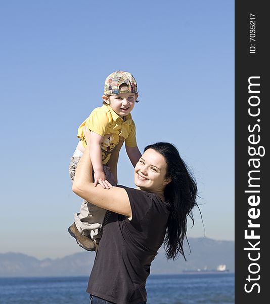 Young women holding little boy on the beach