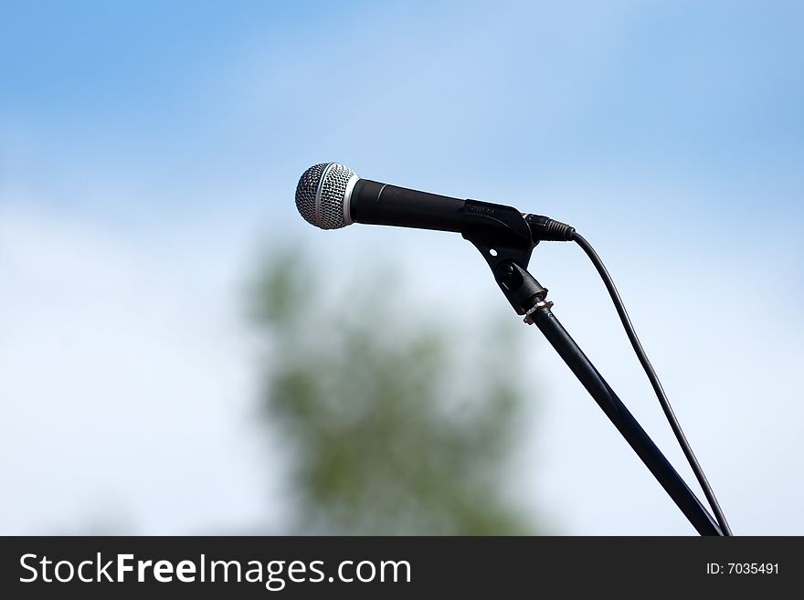 Microphone with stanchion on sky background. Microphone with stanchion on sky background