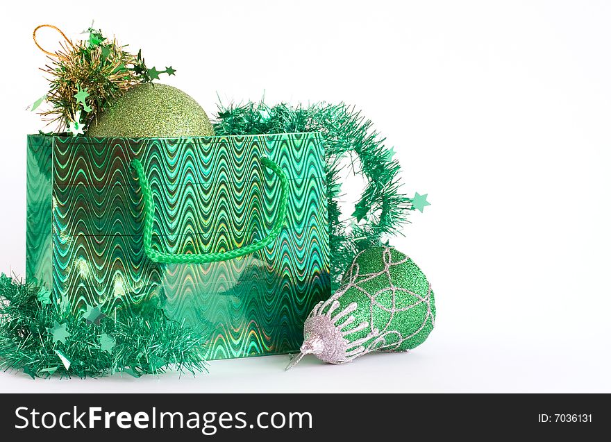 Green bag with christmas toys on white background