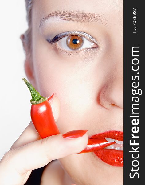 Girl is biting red hot chili pepper