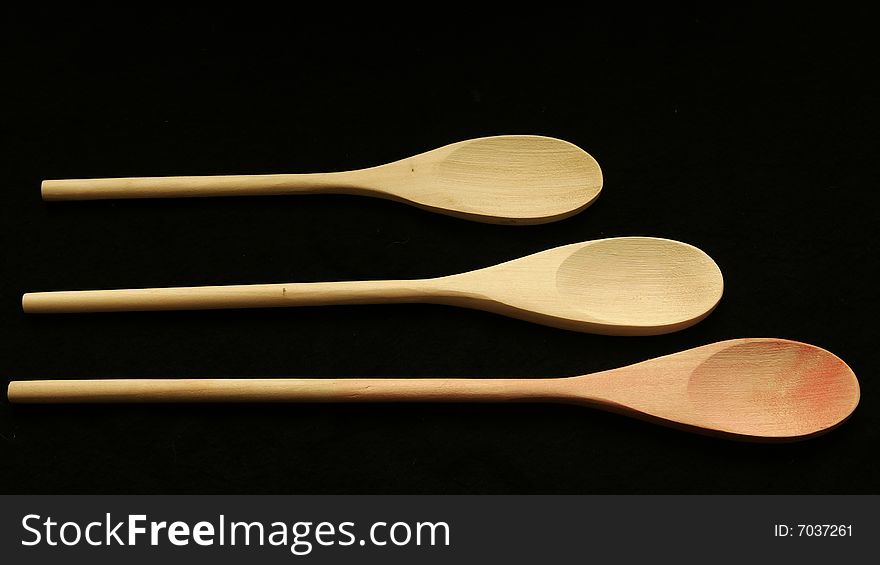 Three wooden spoons lined up on a table