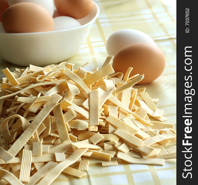 Egg noodles on a table and eggs closeup