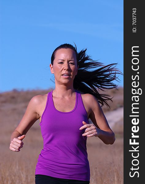 Beautiful female jogger in purple top on a late afternoon. Beautiful female jogger in purple top on a late afternoon