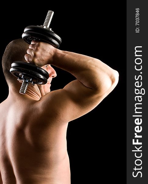 Man lifting weights isolated on black