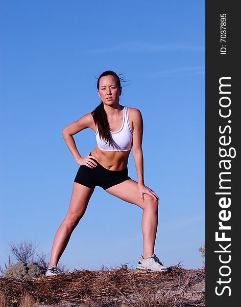 Female jogger with beautiful toned body shielding her eyes. Female jogger with beautiful toned body shielding her eyes