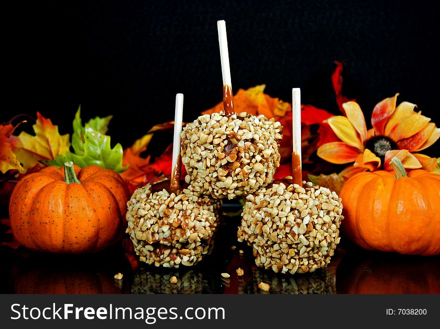 Stack of caramel apples with seasonal gourds and foliage. Stack of caramel apples with seasonal gourds and foliage.